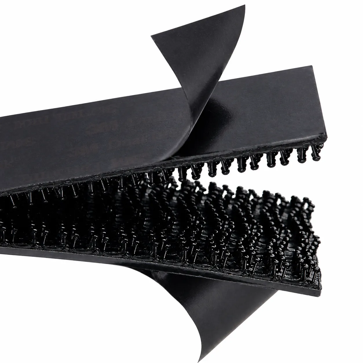 Close-up of the Dual-Lock strips' mushroom-shaped heads, with the adhesive liner peeled back