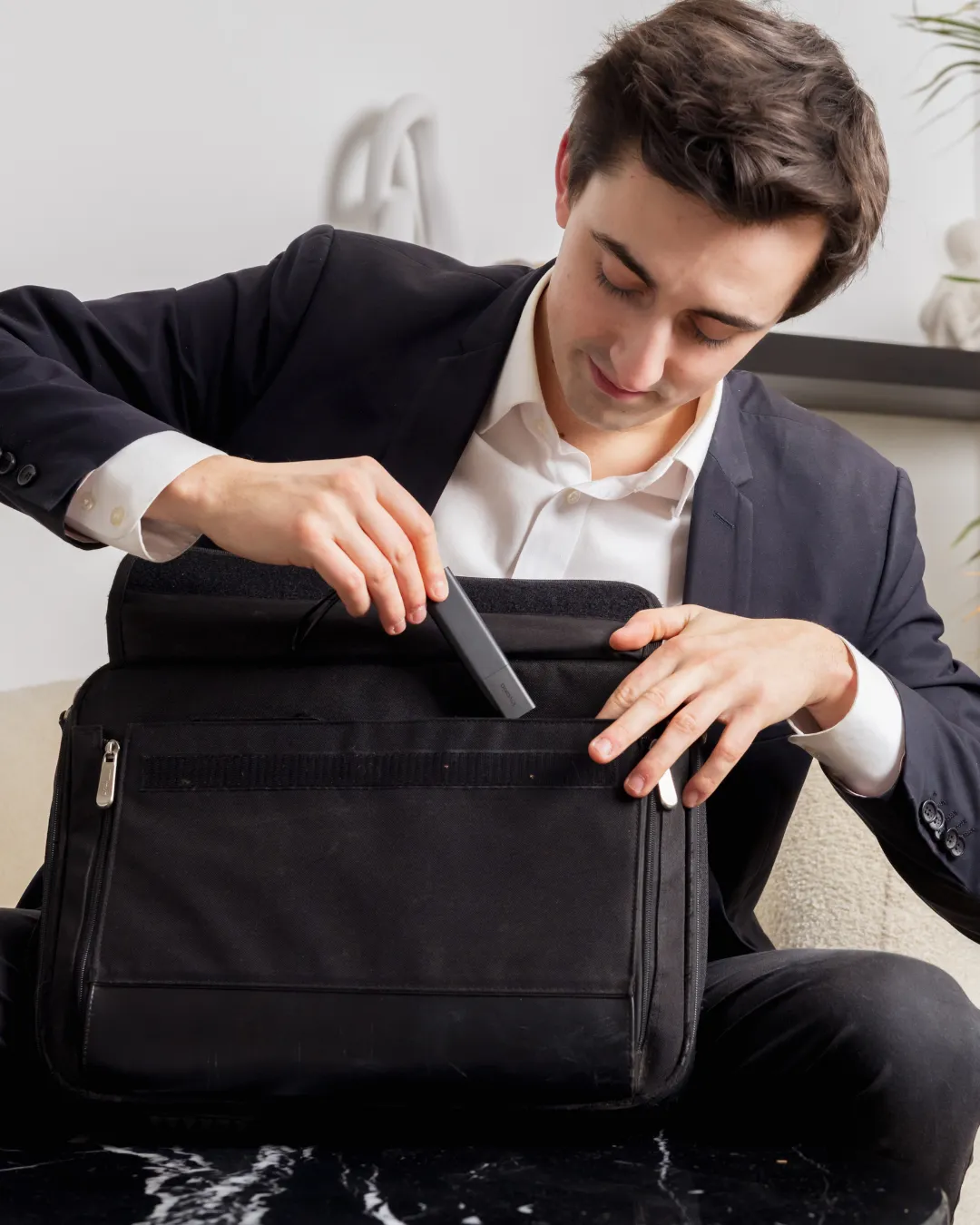 un homme mettant un Tracker GPS Pro dans sa sacoche d’ordinateur