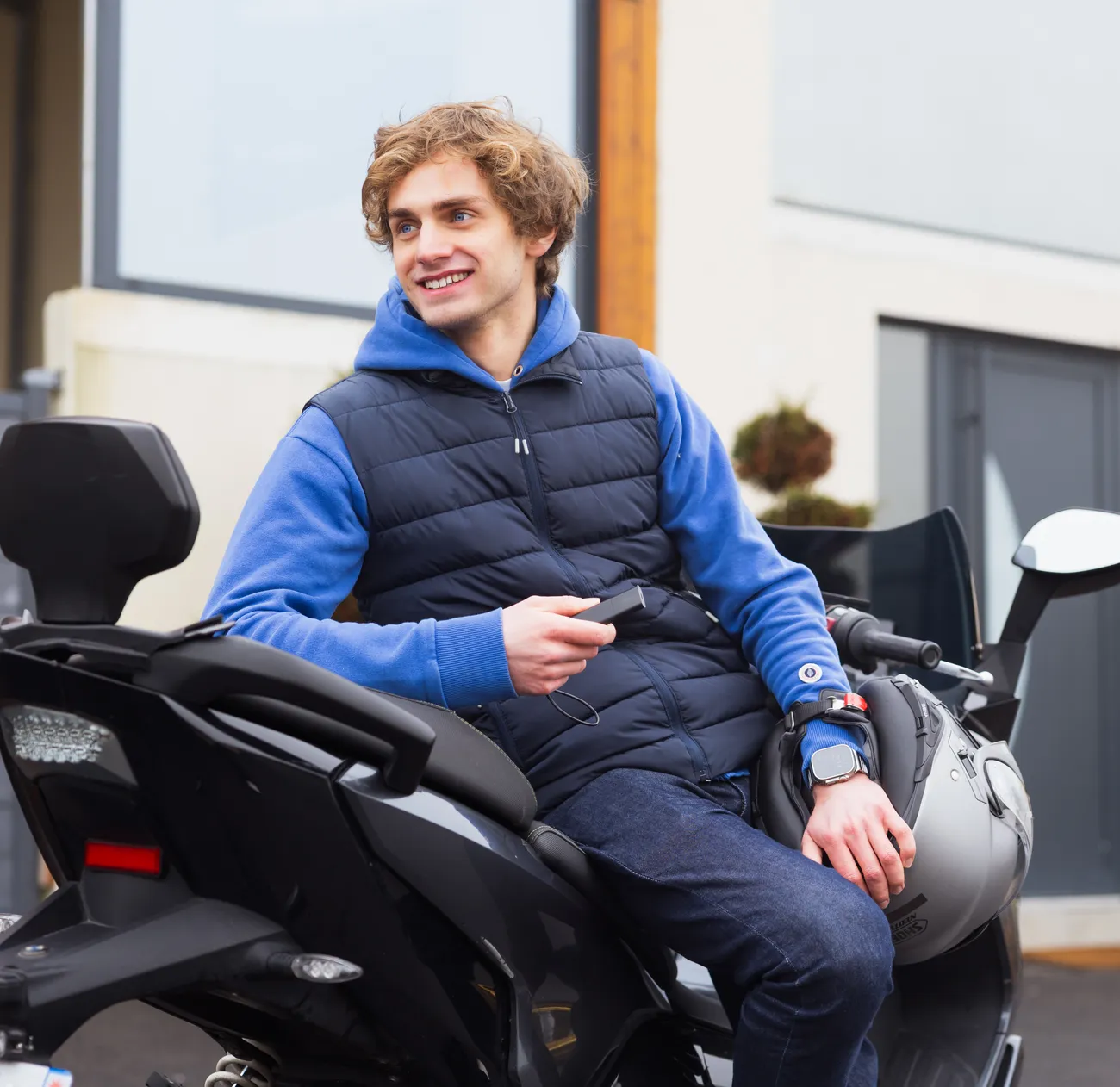 Man on scooter holding a GPS Tracker Pro in its hand
