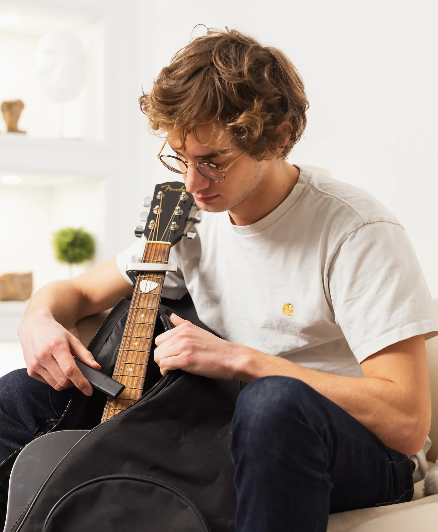 Un jeune homme cache un Tracker GPS Classic dans un étui de guitare