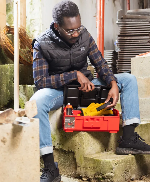 A man prepares to hide a Classic GPS Tracker in a toolbox