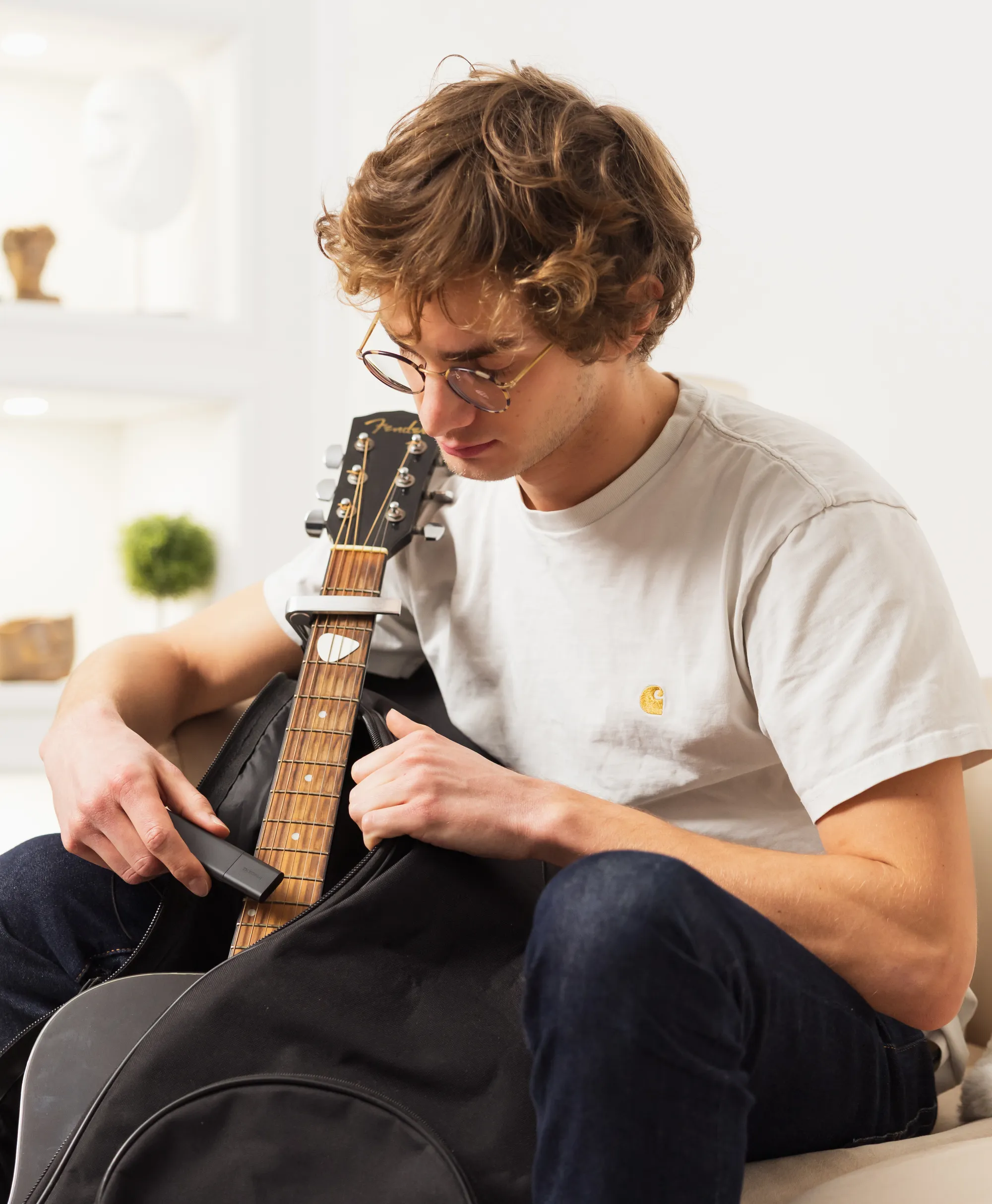 A young man hides a Classic GPS Tracker in a guitar case