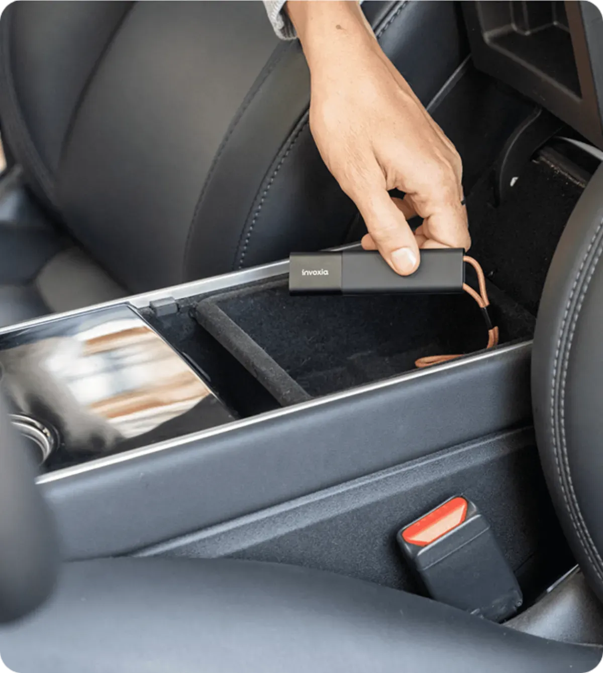 Invoxia GPS Tracker in der Mittelkonsole eines Autos versteckt