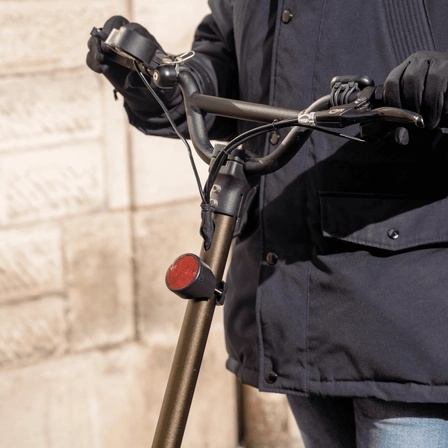 Homme tenant une trottinette électrique équipée d'un Bike Tracker Invoxia