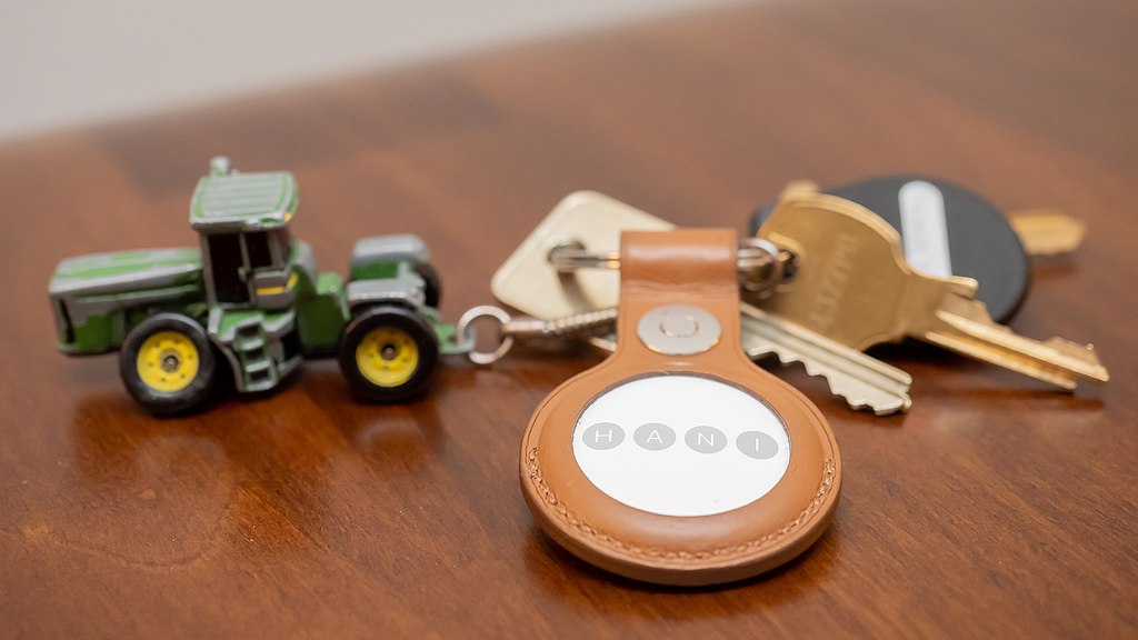 Une personne tenant une clé de voiture avec un porte-clés, représentant l&rsquo;utilisation d&rsquo;Airtag et de trackers GPS pour localiser des objets personnels et des véhicules