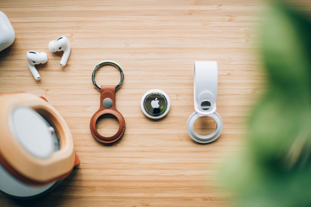 Image 1: AirTag d&rsquo;Apple et accessoires sur une table en bois