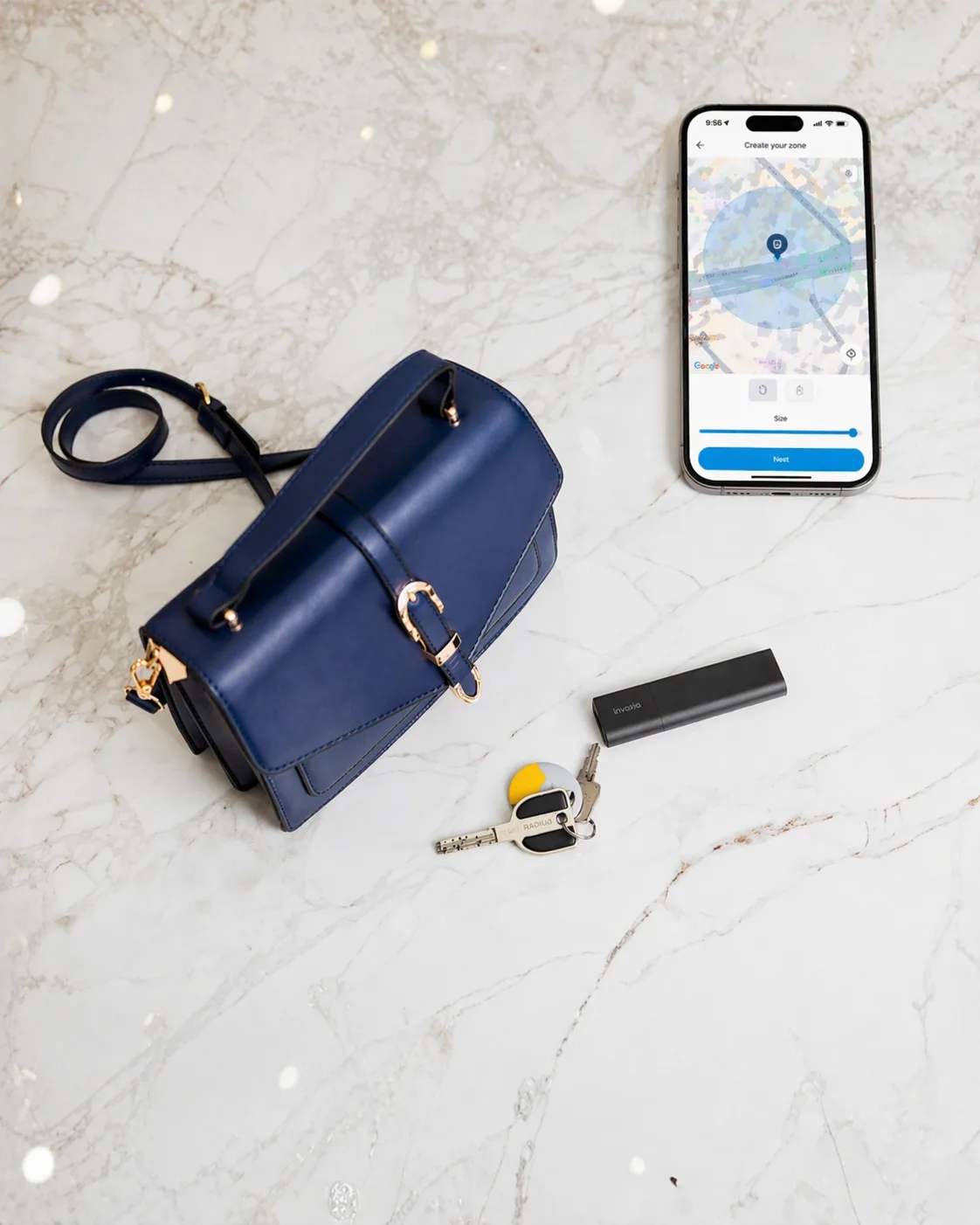 Smartphone showing a safety-zone creation screen next to an Invoxia GPS tracker and keys